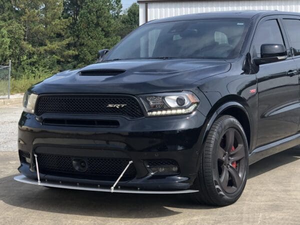 A black dodge suv parked in front of a building