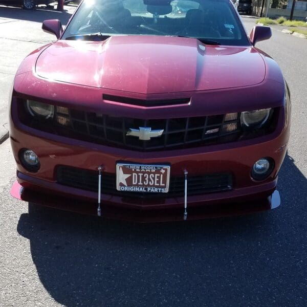 A red chevrolet camaro parked in a parking lot