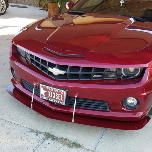 A red chevrolet camaro parked in a driveway