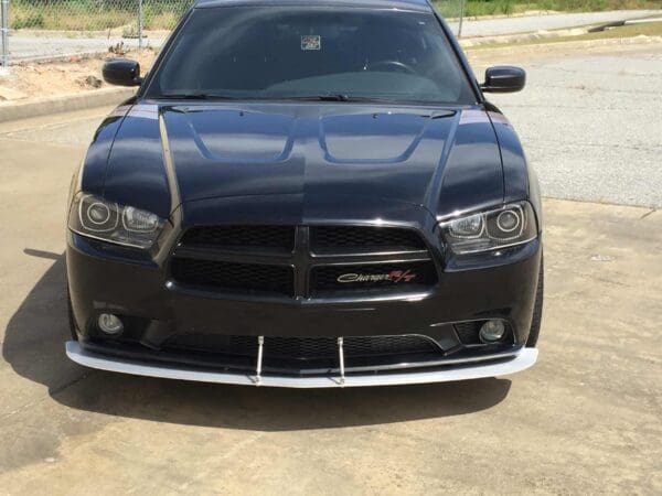 Black Dodge Charger R/T parked in a lot, with a sleek design and visible front grille.