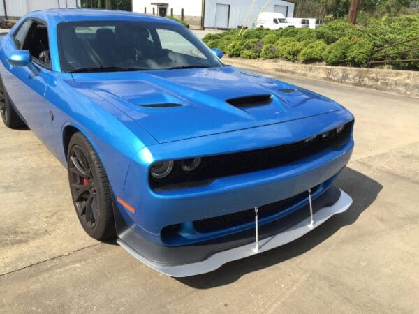 A blue Dodge car parked in a lot, featuring a sporty front design and sleek lines.