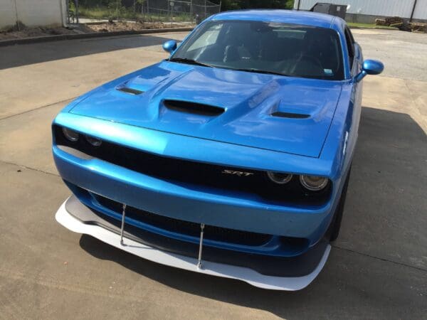 A blue Dodge Charger SRT parked in a lot, showcasing its sleek design and front detailing.