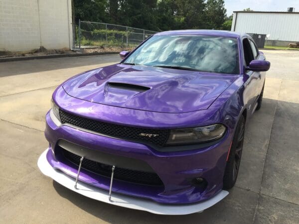 A purple car parked in front of a building