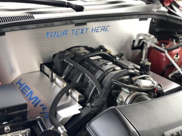 Close-up of a car engine with "HEMI R/T" and "YOUR TEXT HERE" on the cover, showcasing intricate components and wiring.