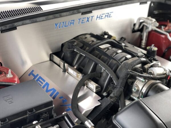 Close-up of a car engine featuring "HEMI R/T" text in blue, with "YOUR TEXT HERE" in the background.