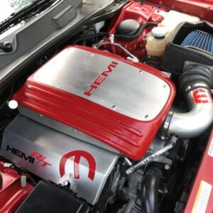 Red HEMI engine in car with chrome accents and air intake.