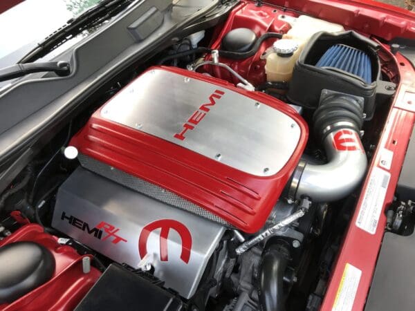 Red HEMI engine in car with chrome accents and a prominent air intake.