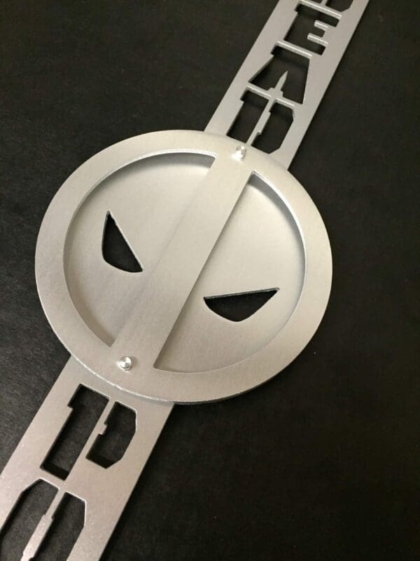 A metal hood prop with the DEADPOOL LOGO