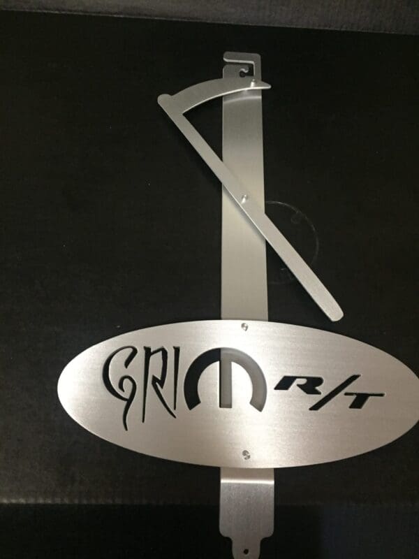 A metal hood prop with the word GRIM RT