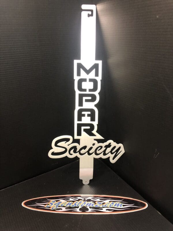 A metal hood prop with the word MOPAR SOCIETY