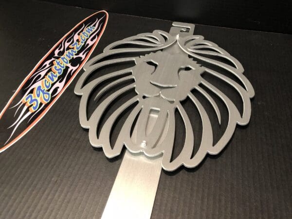 Metallic lion-shaped emblem next to a surfboard-shaped sticker with text.