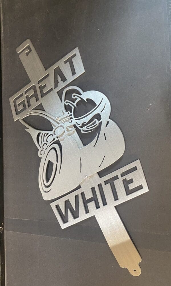 Metallic cutout of a shark and the words "GREAT WHITE" on a dark background.