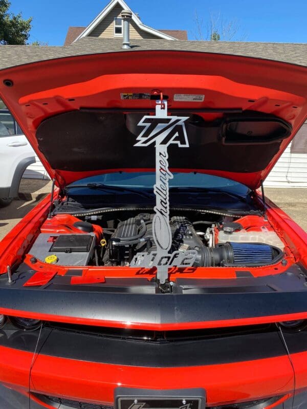 A red sports car with its hood open