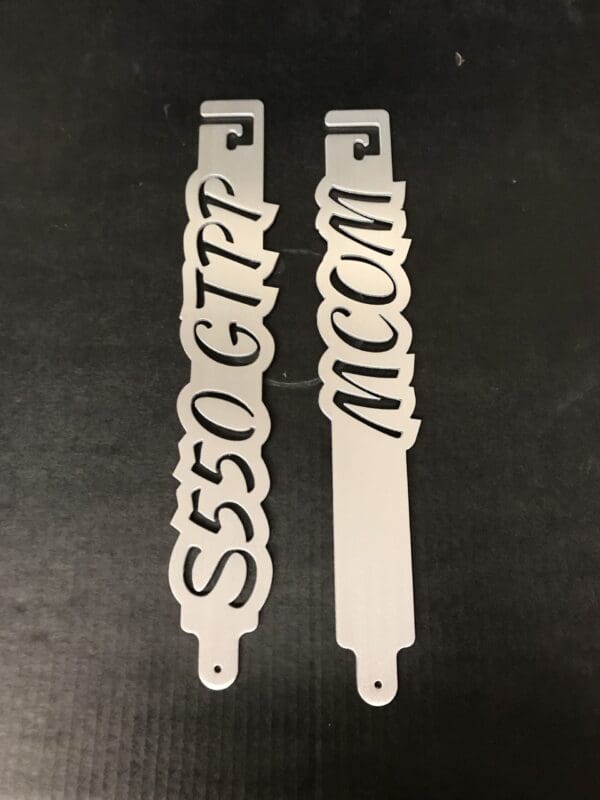 A metal hood prop with the word S550 GTPP MCOM on it