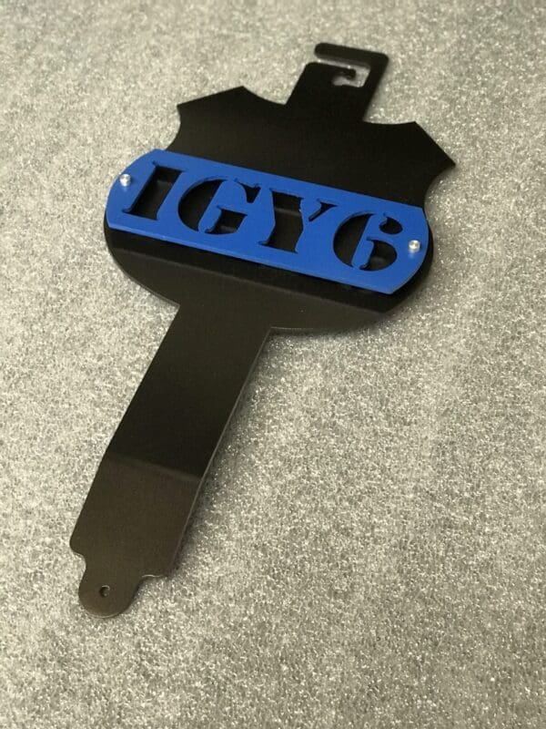 A metal hood prop with the letters IGY6