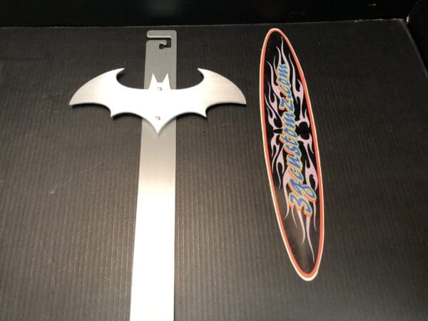 A metal hood prop with the Batman logo
