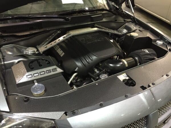 Silver Dodge car with hood open, revealing a HEMI engine and detailed components under the hood.