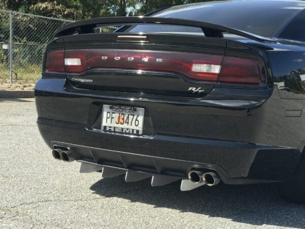 A black Dodge Charger R/T with Georgia license plate PFJ3476, parked in a lot, showing dual exhaust and spoiler.
