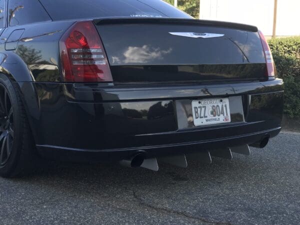 A black Chrysler parked on the roadside with Georgia license plate BZZ8041, featuring rear diffusers and red taillights.