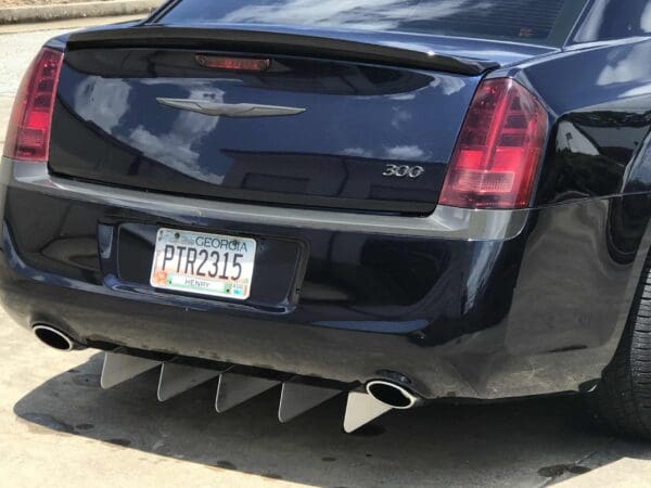 A black Chrysler 300 parked, showing a Georgia license plate PTR2315 from Henry County, with visible rear spoiler and diffuser.
