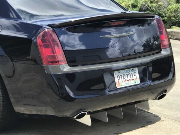 The back end of a black car parked in a driveway