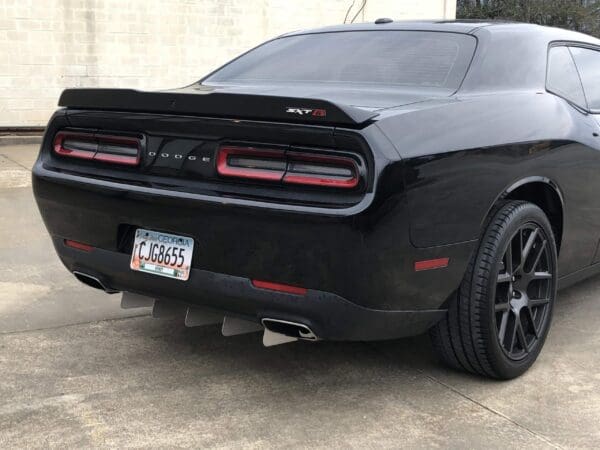 A black Dodge sports car with a Georgia license plate, CJG8655, parked in a driveway.