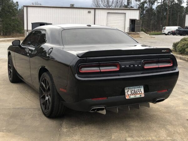 A black Dodge sports car with a Georgia license plate CJG8655 is parked in a parking lot.