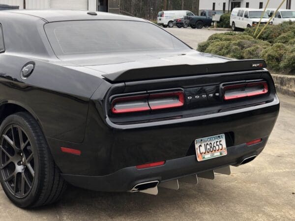 A black dodge car parked in a parking lot