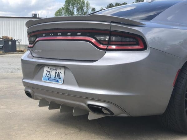 The rear end of a silver dodge charger