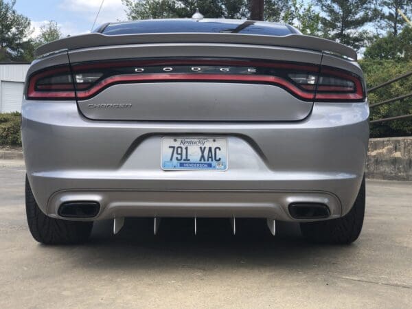 The rear end of a silver dodge charger