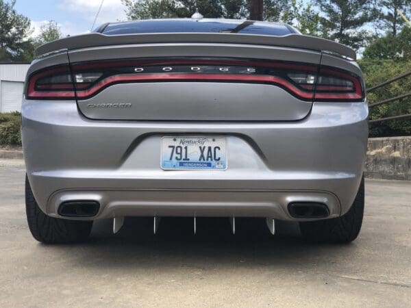 Rear view of a silver Dodge Charger with a Kentucky license plate, parked on a concrete surface.