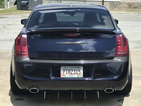 A black Chrysler 300 with Georgia license plate PTR2315 parked in a lot, with a cloudy sky reflection on the trunk.