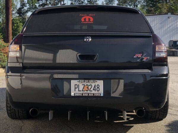 The back end of a black suv parked in a parking lot