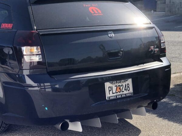 A black SUV with a Georgia license plate "PLZ3248" parked on the roadside, featuring decals like "Fast Girl" and "MOPAR."