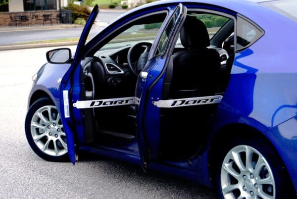 A blue car with its door open on the street