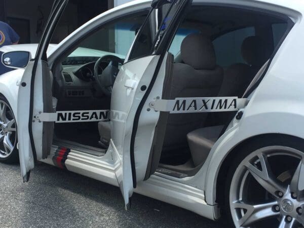 A white car with its door open and the door open