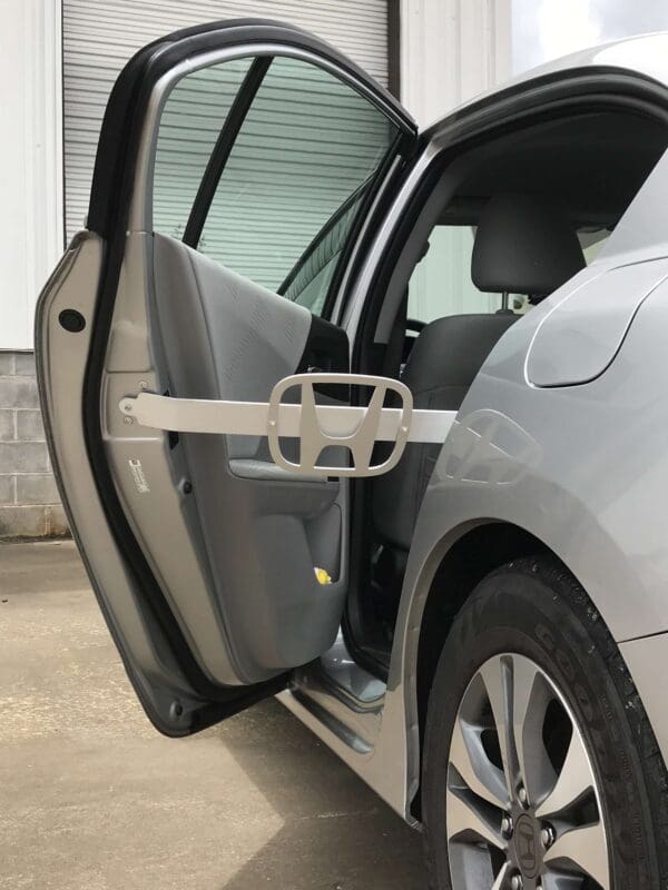 A silver car with its door open and the driver's side door open