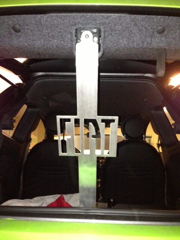 The back of a green car with luggage in the trunk