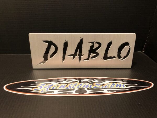 Metal sign with "DIABLO" in bold, jagged letters; below is an oval sticker with "3gcustomz.com" over a flame design.