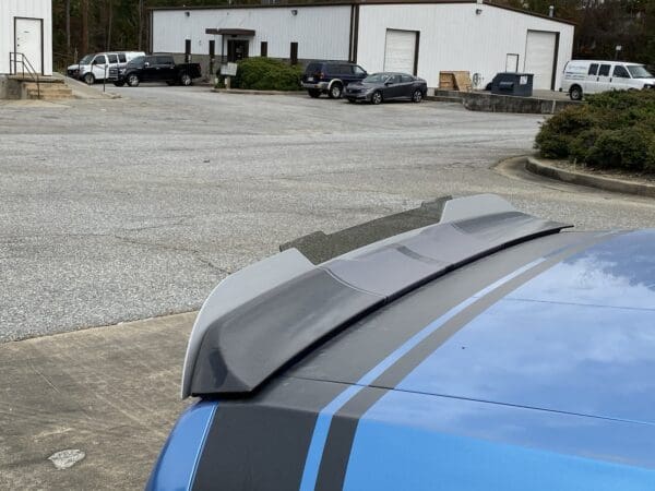 A blue car parked in a parking lot next to a building