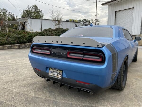 A blue car parked in front of a garage