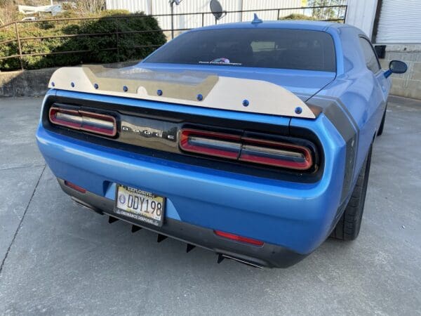 The rear end of a blue car parked in a driveway