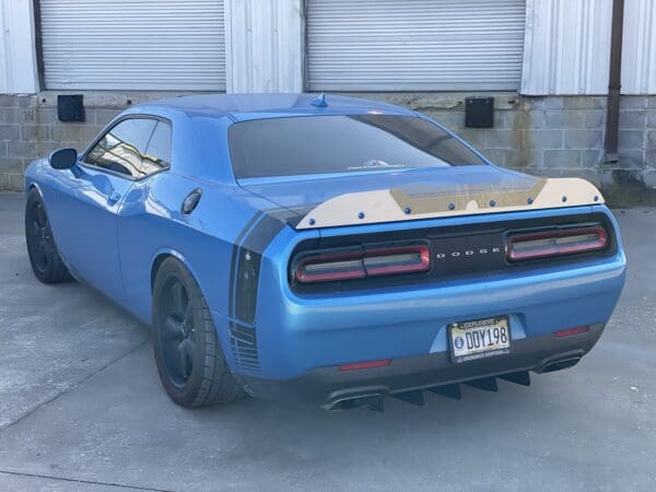 A blue car parked in front of a garage