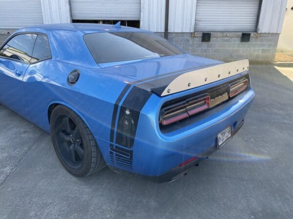 A blue car parked in front of a garage