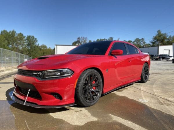 A red dodge charger parked in a parking lot