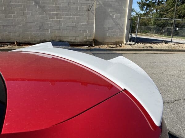 A red and white car parked on the side of the road