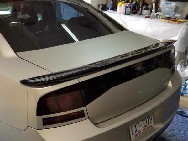 A silver car parked in a garage next to a wall