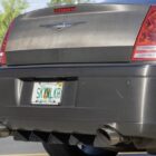 Rear view of a car with a custom rear diffuser and dual exhaust pipes, featuring a personalized license plate.