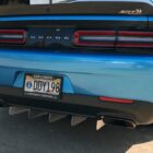Blue Dodge car rear with SRT badge, dual exhaust, and distinctive rear diffuser. License plate visible.