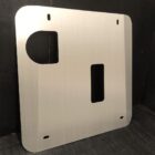 Metal skid plate with cutouts, designed for mounting or protection. Textured background.